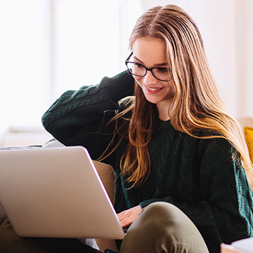 Lady smiling working on laptop